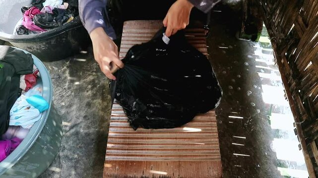 Traditional Laundry Washing Using Hands and Wooden Washboard in Rural Setting