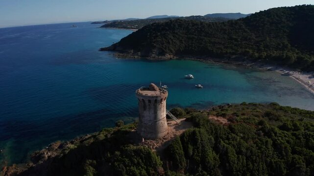 Drone en orbite autour d'une tour en ruine surplombant la mer  
