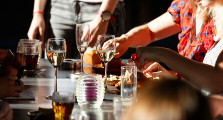 Gathering around a dinner table enjoying delicious food and drinks during a lively evening at a...