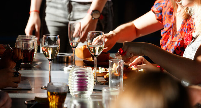 Gathering around a dinner table enjoying delicious food and drinks during a lively evening at a cozy restaurant in the city