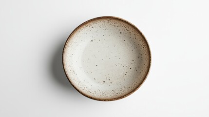 Overhead shot of a speckled ceramic bowl on a white background. The bowl is round with a rustic, speckled design in shades of off white, beige, and