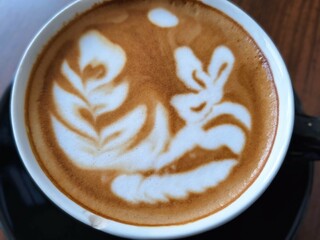 A cup of freshly brewed latte is on the table for breakfast. Morning brew, coffee on the table, morning ritual.
