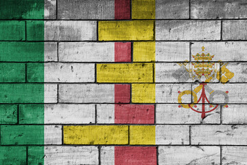 colourful painted big flag of italy and flag of vatican city on a massive old brick wall...