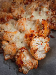 Roasted cauliflower florets seasoned with spices, garnished with melted cheese, serving romantic dinner in prague kitchen