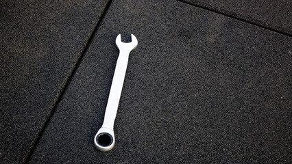 Wrench stands on black background at construction site