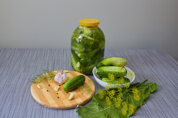 pickled cucumbers in a jar, pickled cucumbers in a jar on the table and fresh cucumbers with garlic