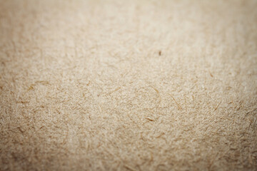 Extreme closeup of beige handmade paper with shallow depth of field.