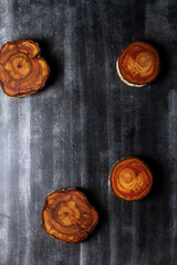 Wood log tree slices on black chalkboard. Flat lay. Top view