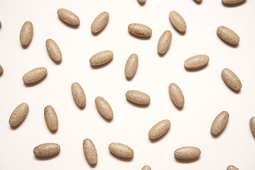 Dietary supplement pills on neutral background.