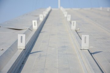 Fototapeta premium large metal roof with evenly spaced vertical ridges and small brackets or mounts attached at regular intervals