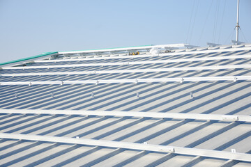 sloped metal roof. The roof has a series of parallel ridges and is equipped with numerous mounting...