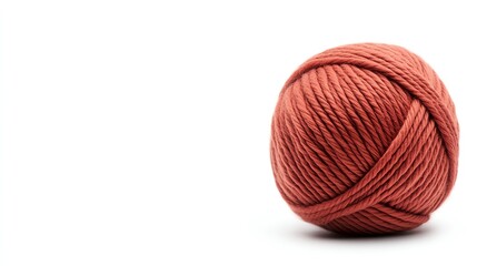 A soft, reddish yarn ball sits on a white background, perfect for knitting or crafting projects.