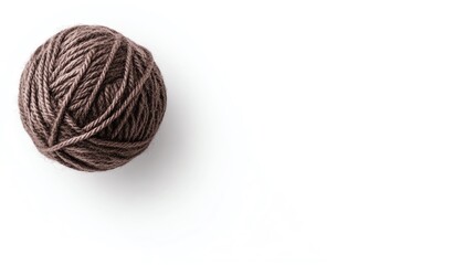 A soft, brown ball of yarn resting on a white surface, perfect for knitting or crafting projects.