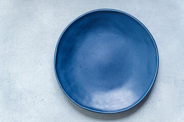 Blue plate set against textured light blue background