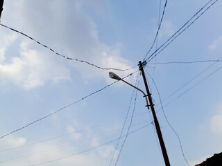 Electric pole with cables visible clouds during the day