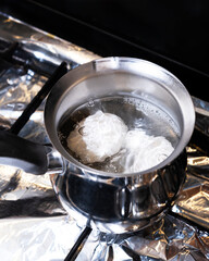 boil eggs in an aluminum pan on a gas stoveGenerated image