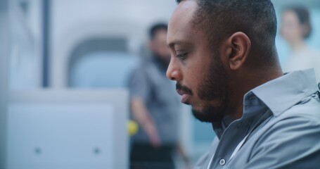 Airport Security Checkpoint: Close Up African American Security Officer Monitors Passenger...
