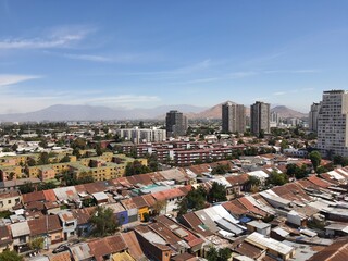North part of Santiago, Chile. Photograph taken from the 15th floor of a building. You can see the roofs of houses, buildings and hills in the background.