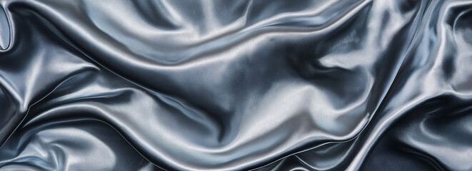 Fototapeta premium A close-up view of the surface texture of silver fabric, showcasing a smooth and slightly wavy appearance. The dark gray background enhances the details of the light blue material, bringing out its su