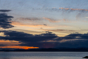 Obraz premium Serene Sunset Over Vancouver Island Coastline with Colorful Clouds and Calm Waters