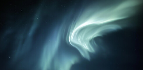 A blurred and grainy photograph featuring an abstract, wavy white shape on the left side, set against a dark background. The shape blends various shades of blue, purple, green, and gray, creating a dy