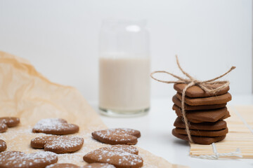 Heart shaped cookies and a glass of milk on a light background. Delicious snack and pastry