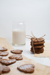 Heart shaped cookies and a glass of milk on a light background. Delicious snack and pastry