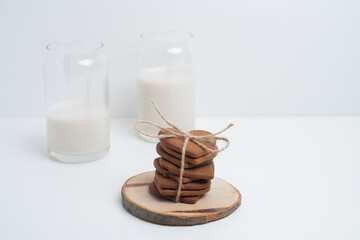 Heart shaped cookies and a glass of milk on a light background. Delicious snack and pastry