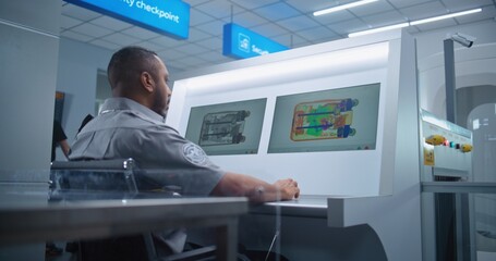African American Security Officer Controls Luggage Screening on Computer Monitors Using Modern...