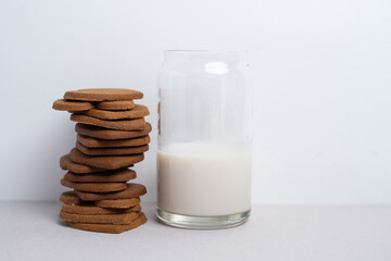 Heart shaped cookies and a glass of milk on a light background. Delicious snack and pastry