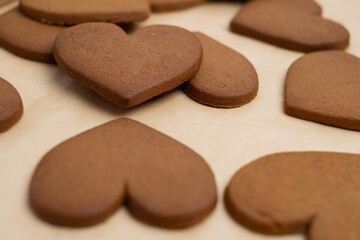 Gingerbread heart cookies on parchment paper. Delicious baking