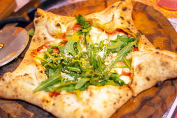 star-shaped italian pizza with tomatoes and arugula