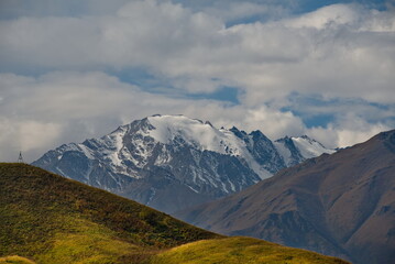 Russia. The Elbrus region. The high mountain peaks of the North Caucasus are surrounded by morning misty clouds hovering at different levels of inaccessible rocks.