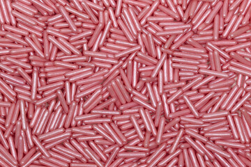 Pink Metallic Rod-Shaped Sugar Sprinkles Pattern: Macro Photography of Decorative Confectionery...