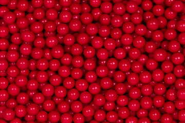 Vibrant Red Sugar Sprinkles Background: Macro Photography of Decorative Candy Pearls Used for Cake Decoration and Confectionery Garnish