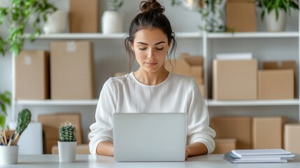 E-commerce+success story. Focused woman working on a laptop in a modern workspace.