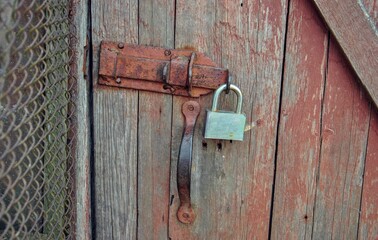 latch with padlock on an old wooden door