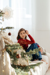 a woman in the Christmas decorated rom with a spruce tree ms Santa