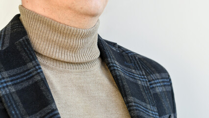 Close up of men casual outwear, dark grey checked blazer combined with beige sweater.  Selective...