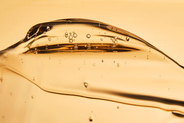 Tasty texture of cosmetic gel on a golden background.