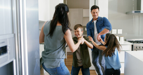 Happy, parents and children with dancing in kitchen for celebration, bonding or learning steps. Energy, woman and man with kids in home for moving together with weekend entertainment, support or love