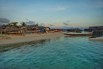 Malaysia. The east coast of the island of Borneo. Sunset on the sandy shore of the reef island of Mabul, famous all over the world for its diving clubs.