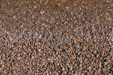 Coarse wet sand on the beach. Natural photo with selective focus