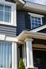 Fototapeta premium Elegant Home Exterior: Modern Architecture, Grey Siding, White Trim, and Black Shutters. A stunning example of residential design with curb appeal.