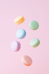 Obraz premium Pastel macarons floating on pink background. Sweet dessert and confectionery concept. Image for bakery and cafe content. Banner view with copy space.