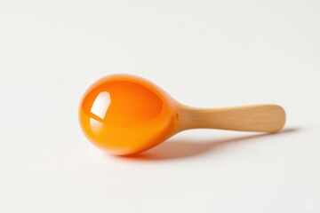 orange glass and wooden maraca toy on a white background