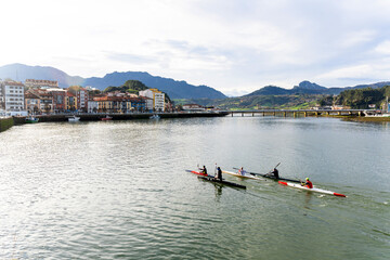 Athletes rowing on sella river in ribadesella, asturias, spain