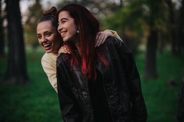 Two close friends sharing a joyful moment outdoors, enjoying the natural forest setting under soft light.