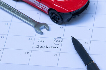 A selected date marked on a calendar with a wrench and a miniature car, symbolizing scheduled vehicle maintenance and repair planning.

