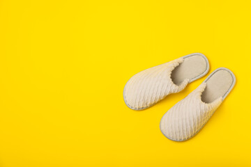 Soft slippers on a bright colored background, close-up. House slippers. Comfortable shoes for home. Foot care concept. Home comfort. Space for text. Copy space.